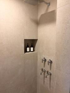 two bottles of wine sitting on a shelf in a shower at The Pavilion at Riverside Park in Kāundia +14 photos