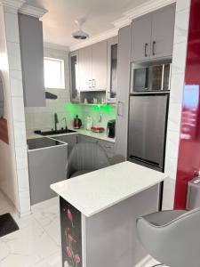 a kitchen with white cabinets and a counter top at Flowsort Grand Apartments 2 in Durban