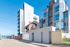 a building on a street next to the ocean at Apartment 100m from Tabuleiro Beachfront CIR0102 in Barra Velha