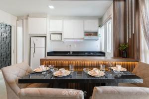 a kitchen with a table with dishes on it at Apartment 100m from Tabuleiro Beachfront CIR0102 in Barra Velha