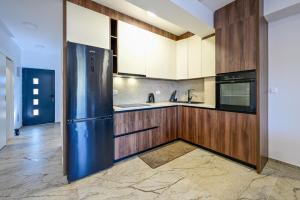 a kitchen with a stainless steel refrigerator and wooden cabinets at Apartman Roso in Orebić