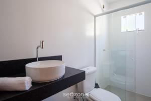 a white bathroom with a sink and a toilet at 2-Bedroom House with Barbecue Area WIL0012 in Imbituba +12 photos