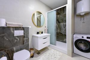 a bathroom with a sink and a washing machine at Apartman Roso in Orebić +19 photos