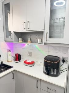 a kitchen with white cabinets and a toaster on a counter at Flowsort Grand Apartments 2 in Durban +21 photos