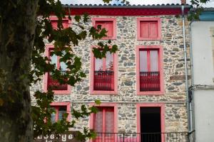 un vecchio edificio in pietra con finestre rosse di Auberge l'Escaleta a Seix