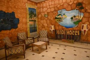 ein Zimmer mit Stühlen und einer Wand mit Wandbild in der Unterkunft Hllol Hotel Abu Simbel in Abu Simbel