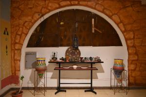 Zimmer mit einem Tisch in einer Steinwand in der Unterkunft Hllol Hotel Abu Simbel in Abu Simbel