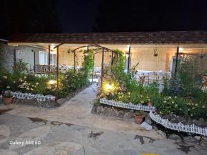 een patio met tafels en stoelen en bloemen in de nacht bij Алрез Гостевой дом in Vardanavan +3 foto's