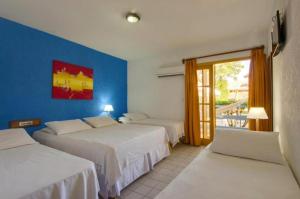 ein Hotelzimmer mit zwei Betten und einem Fenster in der Unterkunft Hotel Estalagem Porto Seguro in Porto Seguro + 40 Fotos