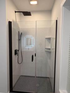 a shower with a glass door in a bathroom at Vineyard Room @ Boulder Mountain View Barn in Twin Mountain