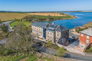 an aerial view of an old building next to a river at 3 Bed in Waren Mill oc-gd1928 in Bamburgh