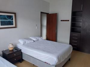 a bedroom with a bed and a dresser and a bed sidx sidx at Casa charmosa com vista e lazer in Belo Horizonte