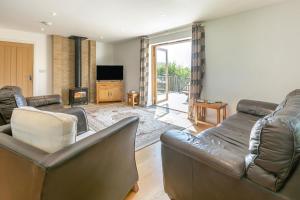 a living room with leather furniture and a fireplace at 3 Bed in Shebbear oc-l32582 in Shebbear
