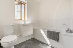 a white bathroom with a toilet and a bath tub at 3 Bed in Shebbear oc-l32582 in Shebbear +23 photos