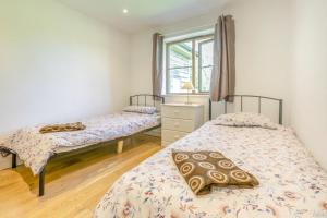 two twin beds in a bedroom with a window at 3 Bed in Shebbear oc-l32582 in Shebbear