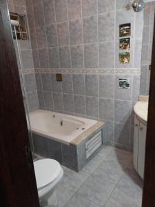 a bathroom with a tub and a toilet and a sink at Casa charmosa com vista e lazer in Belo Horizonte