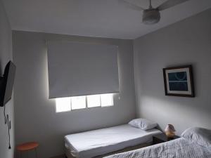 a bedroom with two beds and a window at Casa charmosa com vista e lazer in Belo Horizonte