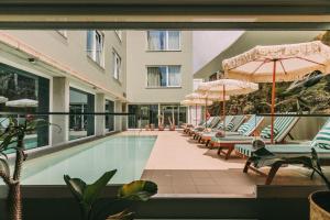 een zwembad met ligstoelen en parasols bij Torel Terra Brava in Angra do Heroísmo