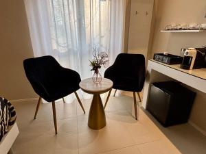two black chairs and a table in a room at Salotto Santa Franca in Piacenza