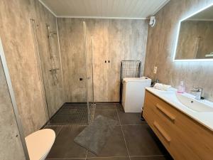 a bathroom with a shower and a sink at Finnvika Panorama Corner in Vestvågøya +14 photos