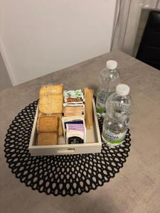 een dienblad met broodjes en flesjes water op een tafel bij GioNi HOUSE in Collegno +6 foto's