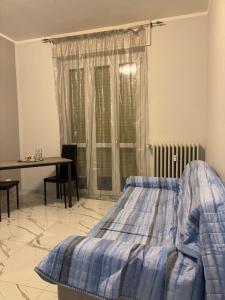 een slaapkamer met een bed, een tafel en een raam bij GioNi HOUSE in Collegno