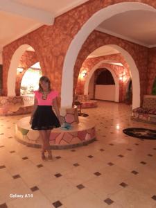 een vrouw in een zwarte jurk die in een lobby staat bij Hllol Hotel Abu Simbel in Abu Simbel +79 foto's