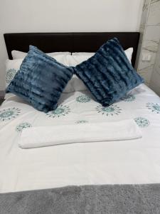 a bed with two blue pillows on top of it at Flowsort Grand Apartments 2 in Durban