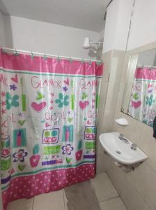 a bathroom with a shower curtain and a sink at Como en casa Hostel in Posadas