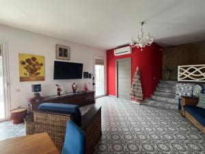 een woonkamer met rode muren en een kerstboom bij Villa GIOBEA in Favara