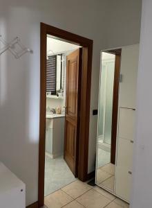 a bathroom with a mirror and a door and a sink at B&B Maria appartamento con stanza matrimoniale e soggiorno vicino alla fiera 2 in Rimini +6 photos