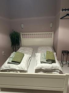 ein weißes Bett mit zwei grünen Kissen darauf in der Unterkunft Blomsterhaven in Glesborg