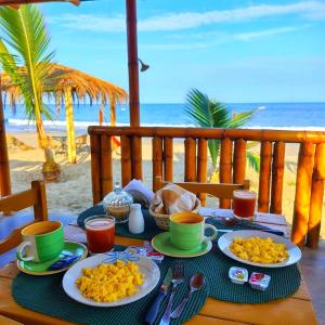 un tavolo con piatti di cibo sulla spiaggia di Bungalows Sol y Mar a Canoas De Punta Sal