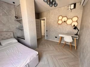 a bedroom with a bed and a desk and a chair at Golden Bugas Sea View Золотий бугаз in Karolino-Buhaz