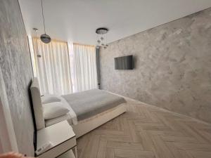 a bedroom with a bed and a television in it at Golden Bugas Sea View Золотий бугаз in Karolino-Buhaz +3 photos