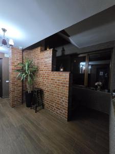 Zimmer mit Ziegelwand und Topfpflanze in der Unterkunft Casa Yna in Buşteni