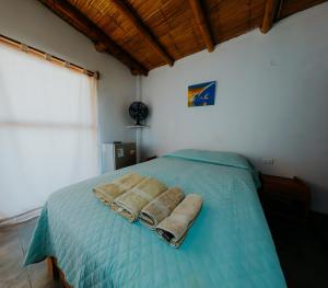 una camera da letto con un letto con due asciugamani sopra di Bungalows Sol y Mar a Canoas De Punta Sal
