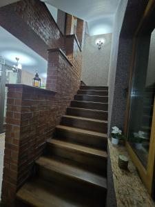 eine Treppe mit einer Ziegelwand und einem Ziegeltreppenhaus in der Unterkunft Casa Yna in Buşteni