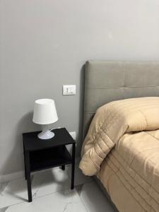 a bed with a side table with a lamp on it at GioNi HOUSE in Collegno