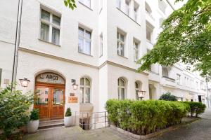 un bâtiment blanc avec une porte marron dans une rue dans l'établissement Arco Smart City Hotel - Berlin KU'DAMM, à Berlin