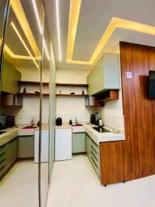 a kitchen with green and white counters and cabinets at Flat 02 Residencial ibiapaba in Camocim