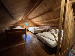 a room with two beds in a wooden cabin at Chalet en lisiere de Foret in Lacanau