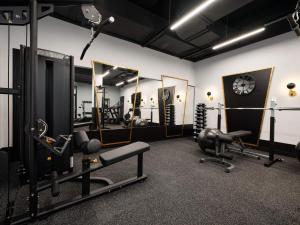 a gym with several machines and a clock on the wall at Cozy Duo Loft Studio in Tartu