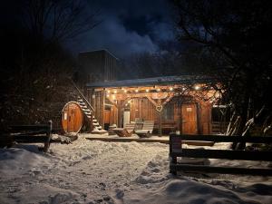a wooden cabin with lights on it in the snow at Romantická chatka so saunou v prírode in Turany +17 photos