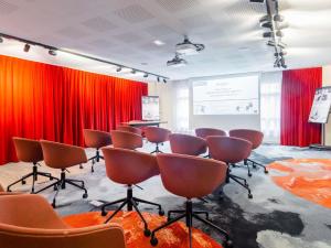 a conference room with red curtains and chairs at Mercure Paris Massy Gare TGV in Massy