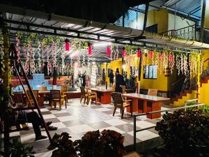 a restaurant with tables and chairs and decorations at Deepdaya Cottage in Alībāg