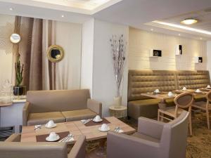 un ristorante con tavoli e sedie e una sala da pranzo di Mercure Toulouse Centre Wilson Capitole a Tolosa