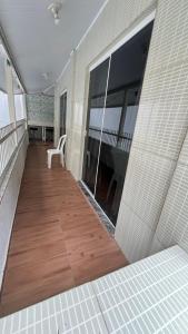 a balcony with a wooden floor and a table at Casas de Aluguel da Lulu in Itapema