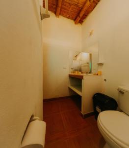 un piccolo bagno con servizi igienici e specchio di Bungalows Sol y Mar a Canoas De Punta Sal Altre 23 foto