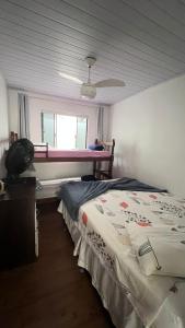 a bedroom with a bed and a window at Casas de Aluguel da Lulu in Itapema +17 photos